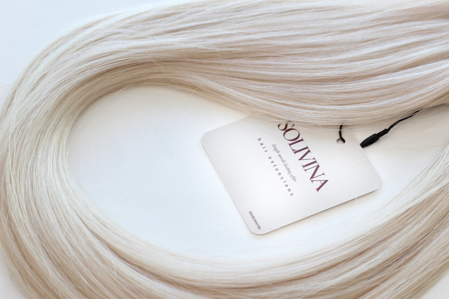 Blonde hair extensions with a Solivina label on a white background